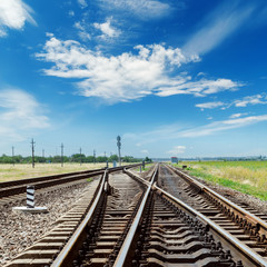 Fototapeta na wymiar crossing of railroads and blue sky with clouds