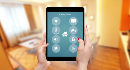 Female using smart home remote control on tablet in living room