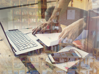 Double exposure of Businessmen use computers and blur library books