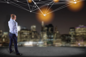 Businessman in front of a wall with Web operating system screen and network connection displayed on an interface- Device connection concept