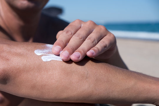 Man Applying Sunscreen To His Arm