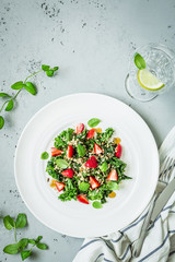 Salad with kale, strawberries, quinoa and mint leaves