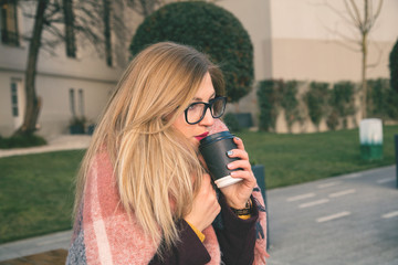 Cute girl drinking hot coffee on the city.Winter portrait.