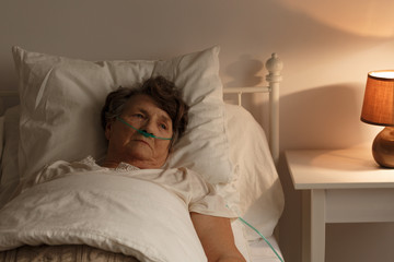 Sick senior woman in bed - obrazy, fototapety, plakaty