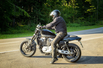 Obraz na płótnie Canvas The biker sits on a motorcycle