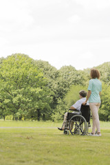 Obraz premium Young nurse with senior woman in middle of the garden