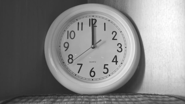 clock is on the shelf black and white