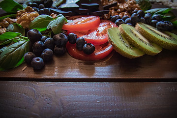 Some nuts, blueberries, dark chocolate, kiwi and tomatoes that are healthy foods for you body and your brain.