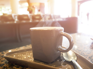 Hot cup of coffee on the table in sunlight