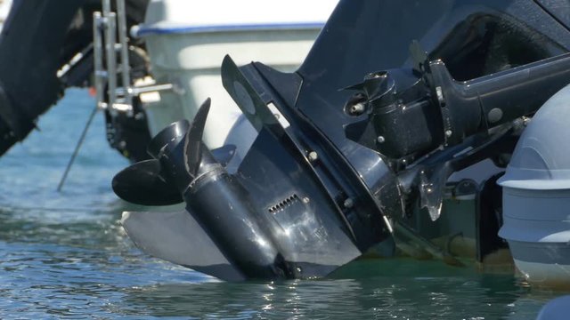 Harbor parked speedboat engine and propeller.