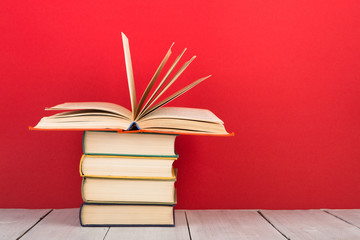 education and wisdom concept - open book on wooden table, color background