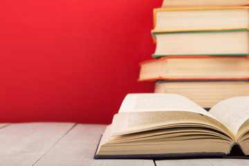 education and wisdom concept - open book on wooden table, color background