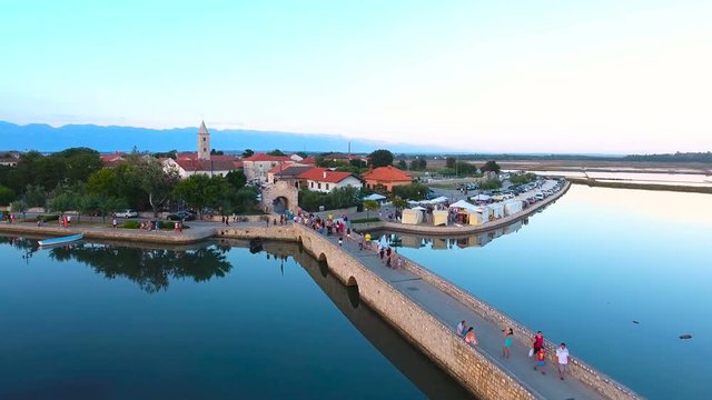 Nin town with people walking over bridge aerial view 4K