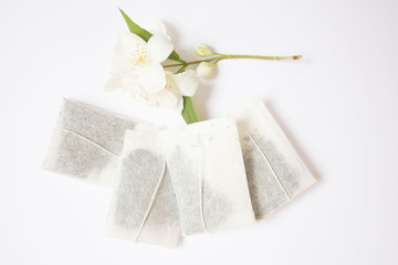 tea bags with cherry flowers on white background