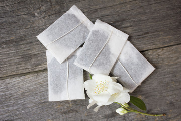 tea bags with cherry flowers on wooden background