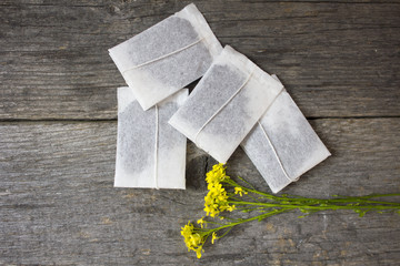tea bags with flowers of oregano on wooden background