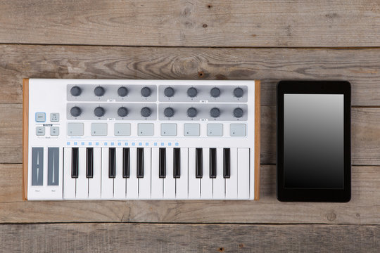 Close up of MIDI controller volume fader, knob and keys.