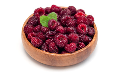 Ripe wild raspberry in wooden bowl, isolated on white background
