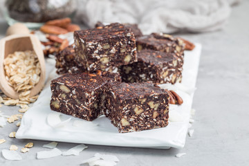 Paleo chocolate energy bars with rolled oats, pecan nuts, dates, chia seeds and coconut flakes,...