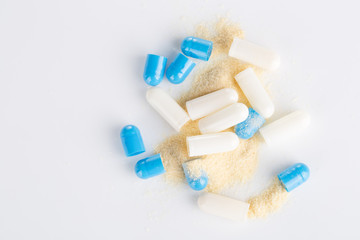 Top view of blue capsule and open capsule on the white background.