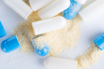 Top view of blue capsule and open capsule on the white background.