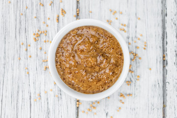 Fresh made Mustard (sweet) on a rustic background