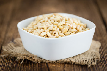 Wooden table with Pine Nuts (selective focus)