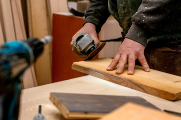 Carpenter working with wood and grinder