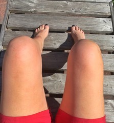 Frauenbeine beim Sonnenbaden im Sommer