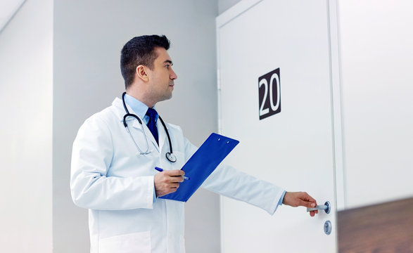 Doctor With Clipboard Opening Hospital Ward Door