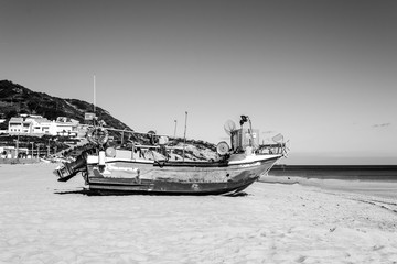 Fototapeta premium Stranded boat in the beach of Salema (Algarve, Portugal)