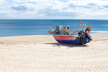 Naklejka premium Stranded boat in the beach of Salema (Algarve, Portugal)