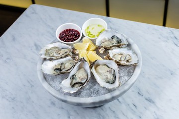 Fresh oysters platter with sauce and lemon