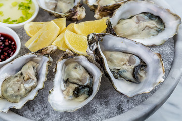 Fresh oysters platter with sauce and lemon