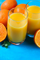 Orange juice - two glasses on blue wooden table, close up view
