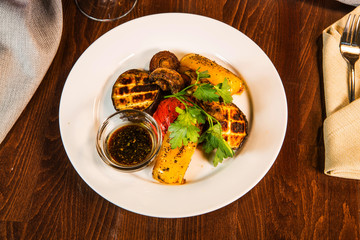 Grilled vegetables. Vegetables grilled with wine on the table in the restaurant interior