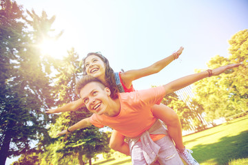 happy teenage couple having fun at summer park