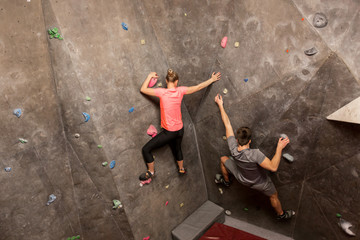 Fototapeta na wymiar man and woman exercising at indoor climbing gym