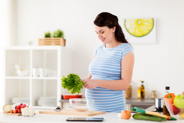Obraz na płótnie Canvas pregnant woman cooking vegetable salad at home