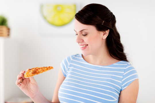 Happy Woman Eating Pizza At Home Kitchen