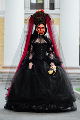 Witch portrait in black vintage dress. Woman widow with red art make-up for halloween.