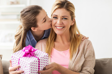 girl giving birthday present to mother at home