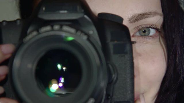 A woman takes on the camera. A woman takes the Picture on the camera. The camera is in the process of close-up shooting. Shutter release in slow motion.