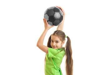 Portrait of a little girl which is raised above the head soccer ball