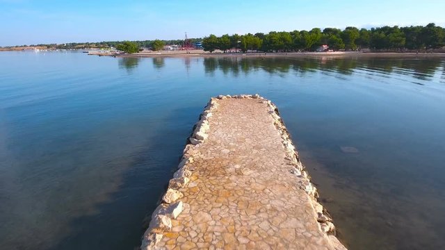 Flying from sea pier above beautiful beach 4K