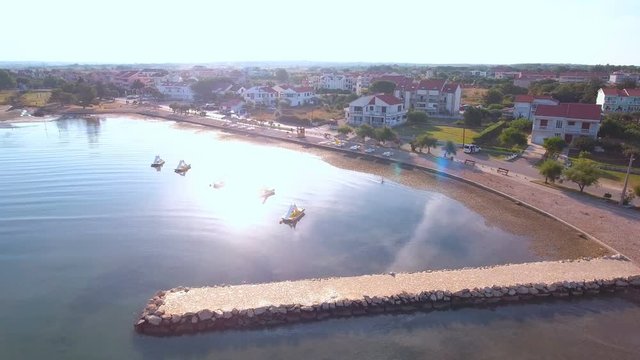 Aerial push-out of Zaton sea coast with sun reflection 4K