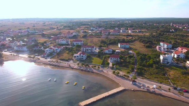Flying over sea to coast with many apartments around 4K