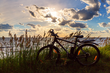 Fototapeta na wymiar Bike by the river in the setting sun. Siberia, Russia