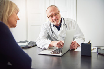 Diagnosis specialist talking to woman showing her laptop