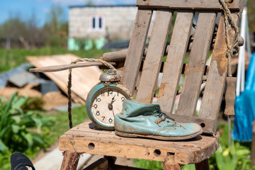 Old watches and a children's boot stand on an old broken highchair